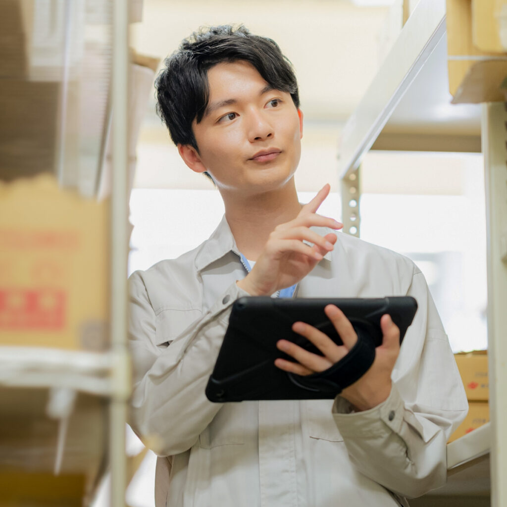 タブレットを用い検品をする男性